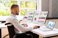 person in wheelchair looking at data on laptop